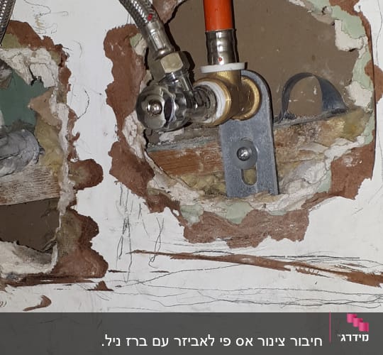צינור מתכת וברז בתוך קיר פתוח